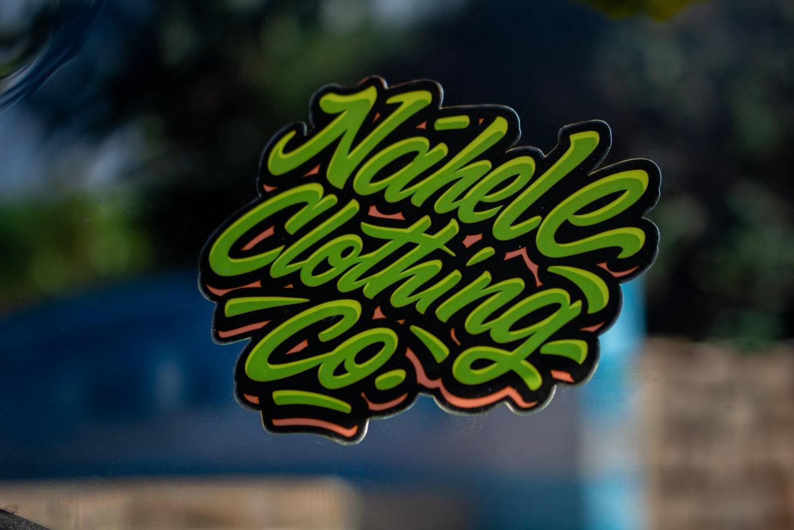 Nāhele Clothing Co. “Concrete Bloom” Sticker - Nāhele Clothing Co. - Nahele Co. - Nahele Clothing Co. - Sticker with 'Nahele Clothing Co.' text on a blurred background